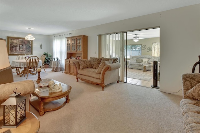 carpeted living room featuring a wealth of natural light and ceiling fan