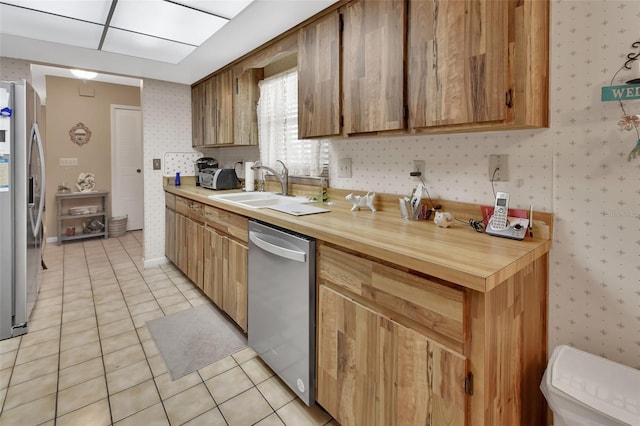 kitchen with light tile patterned floors, sink, and appliances with stainless steel finishes