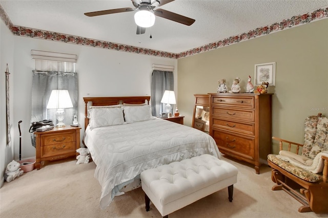 bedroom with a textured ceiling, ceiling fan, and light carpet