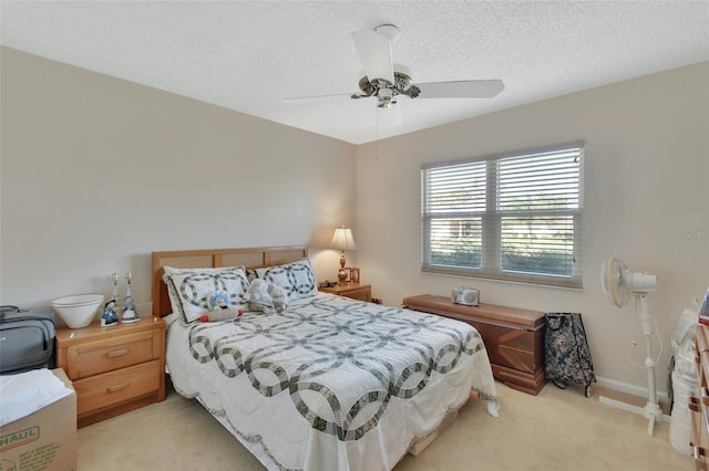 bedroom with a textured ceiling, ceiling fan, and light carpet