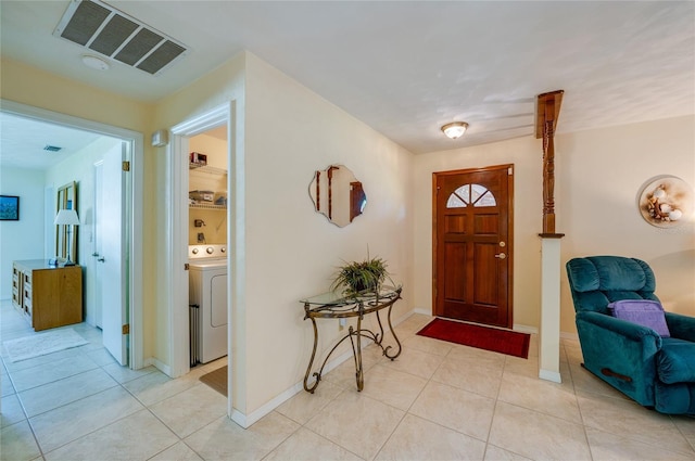 entryway with washer / clothes dryer and light tile patterned floors