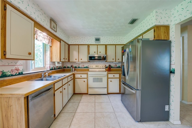 kitchen featuring light tile patterned floors, sink, and appliances with stainless steel finishes