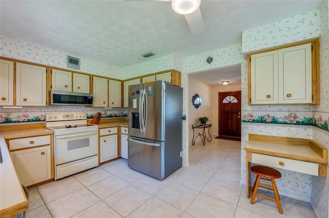 kitchen with ceiling fan, light tile patterned floors, and appliances with stainless steel finishes