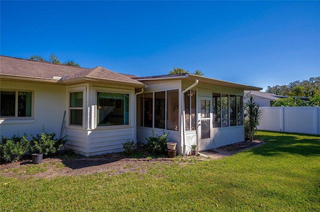 view of side of property featuring a sunroom and a yard