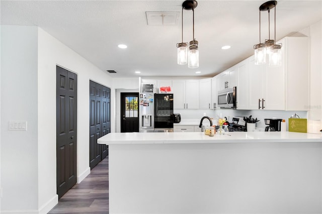 kitchen featuring white cabinets, appliances with stainless steel finishes, dark hardwood / wood-style floors, and hanging light fixtures