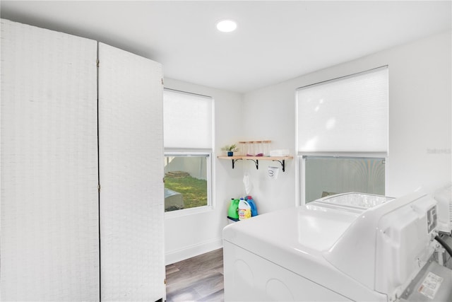 laundry room with hardwood / wood-style flooring and washing machine and clothes dryer