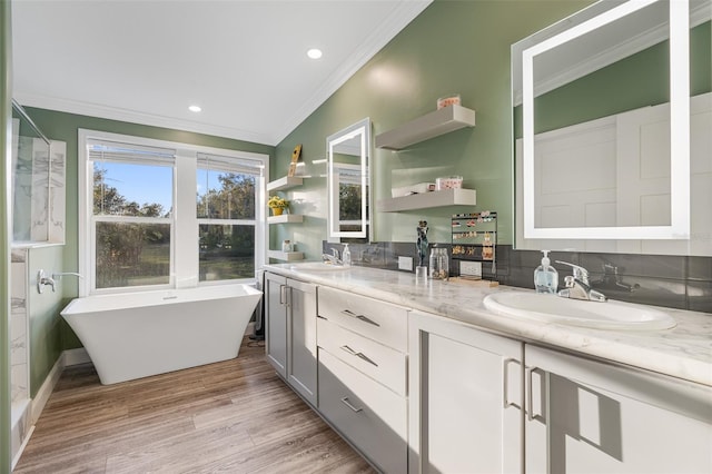 bathroom with crown molding, wood-type flooring, vanity, a bath, and backsplash