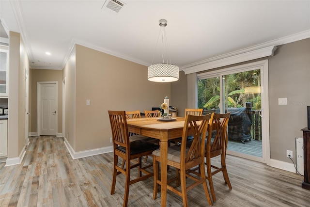 dining room featuring ornamental molding and light hardwood / wood-style floors