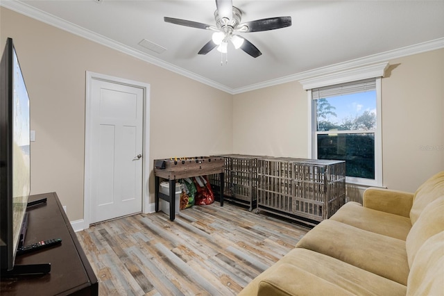interior space featuring ceiling fan, wood finished floors, and crown molding