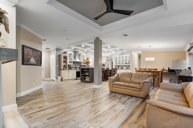 living area with ornamental molding, visible vents, a ceiling fan, and light wood-type flooring