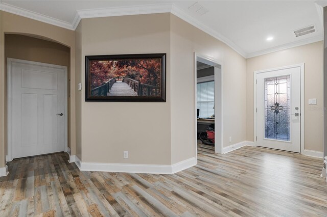 entryway with ornamental molding, visible vents, and light wood-style floors