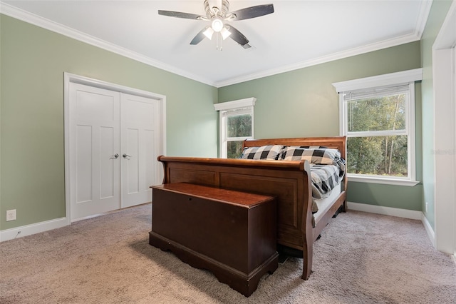 carpeted bedroom featuring a ceiling fan, crown molding, and baseboards