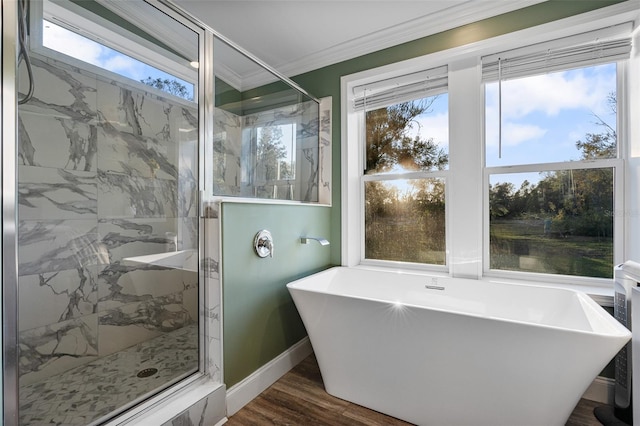 bathroom featuring a marble finish shower, wood finished floors, baseboards, a freestanding bath, and ornamental molding