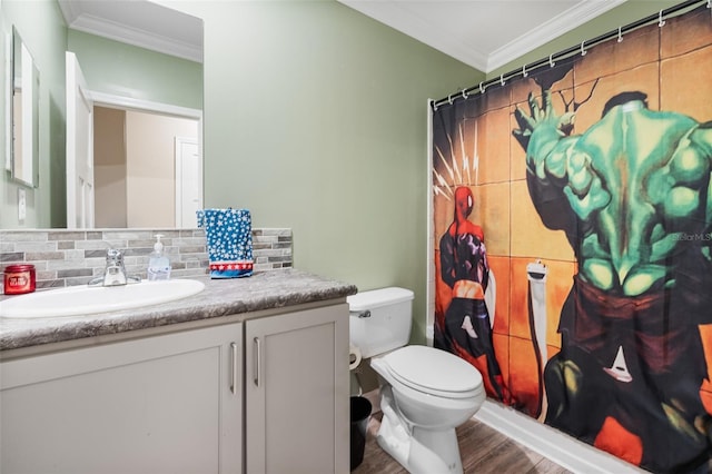 bathroom featuring crown molding, toilet, vanity, wood finished floors, and decorative backsplash