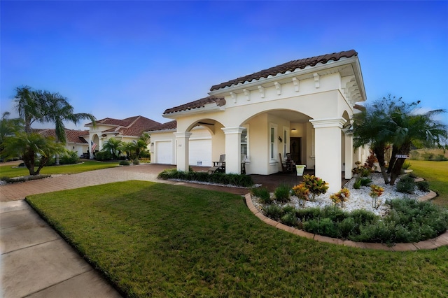 mediterranean / spanish-style house featuring a garage and a front yard