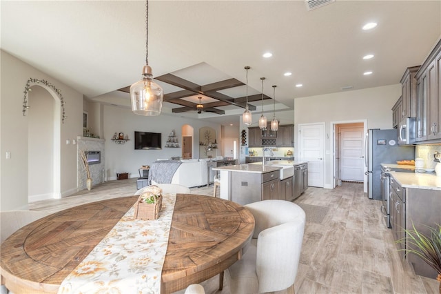 dining space with coffered ceiling, sink, light hardwood / wood-style flooring, ceiling fan, and beam ceiling