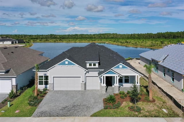 view of front of property with a garage and a water view