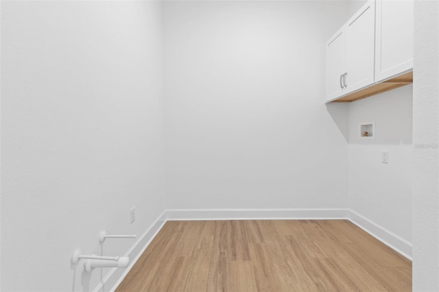 washroom featuring hookup for a washing machine, cabinets, and light hardwood / wood-style floors