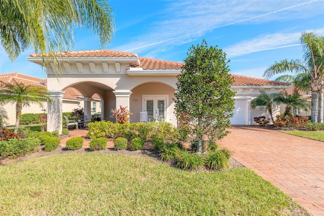 mediterranean / spanish home featuring a front lawn