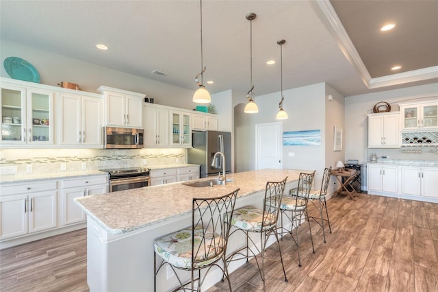 kitchen featuring decorative light fixtures, light hardwood / wood-style flooring, appliances with stainless steel finishes, and tasteful backsplash