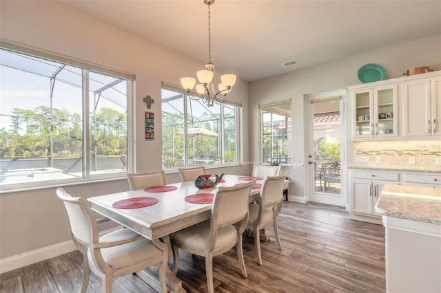 dining space with hardwood / wood-style flooring and a chandelier