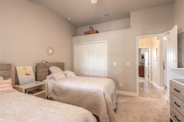 bedroom with light carpet, a closet, and lofted ceiling