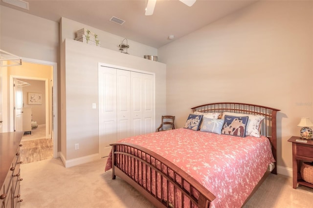 carpeted bedroom with ceiling fan, lofted ceiling, and a closet