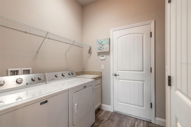 laundry area with cabinets, dark hardwood / wood-style flooring, sink, and washing machine and clothes dryer