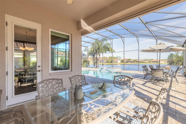 view of patio / terrace featuring a lanai and a water view