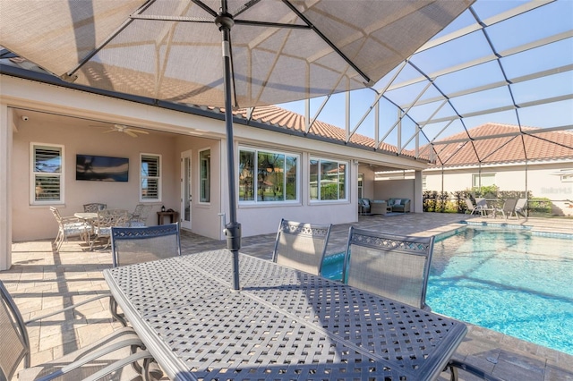 view of swimming pool featuring ceiling fan, a patio area, and glass enclosure