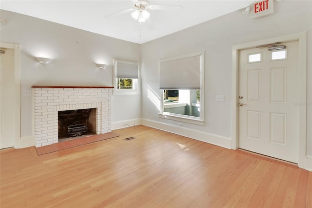 unfurnished living room featuring ceiling fan, light wood-type flooring, and a fireplace