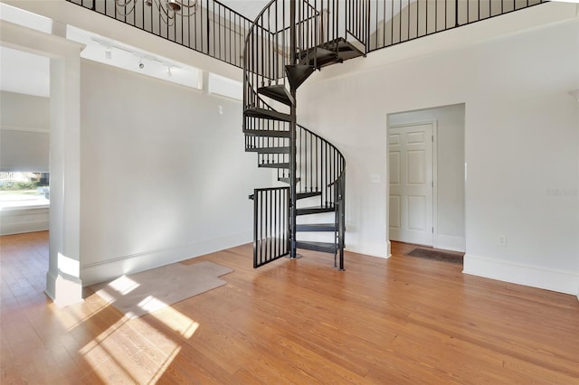 stairs featuring hardwood / wood-style floors and a high ceiling