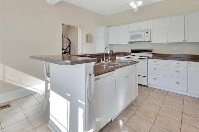 kitchen with sink, white cabinets, light tile patterned flooring, and white appliances