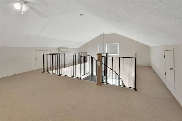 bonus room with a wall mounted air conditioner, light colored carpet, ceiling fan, and lofted ceiling