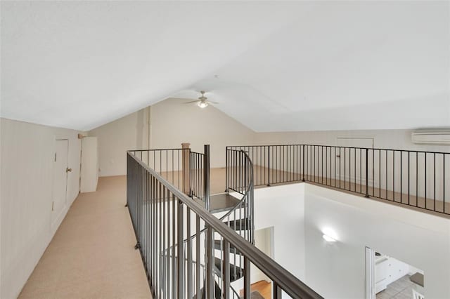 hallway featuring lofted ceiling, light colored carpet, and a wall mounted air conditioner