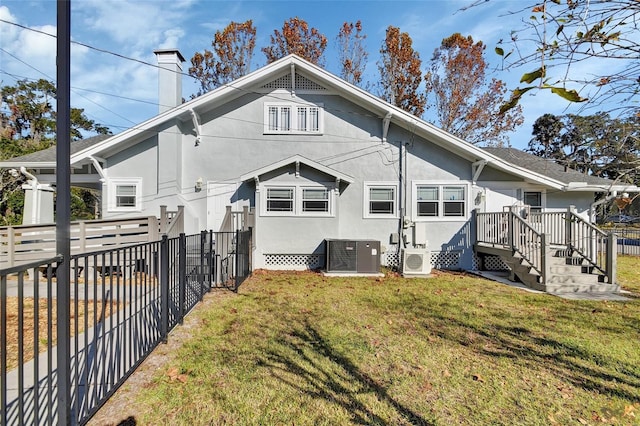 back of house featuring ac unit, a yard, and central AC unit