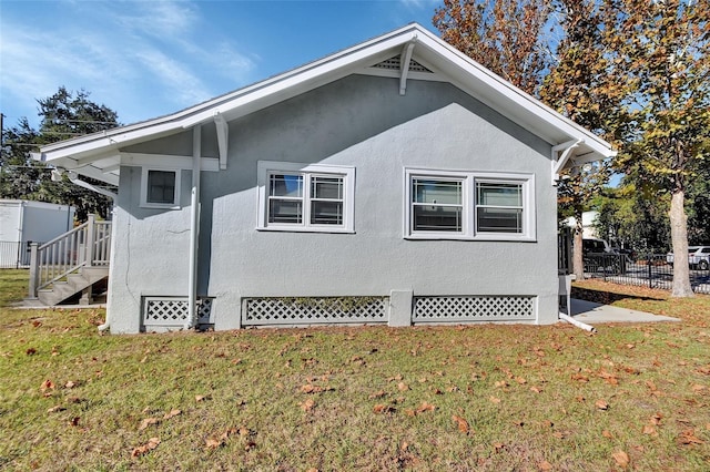 view of side of home with a yard