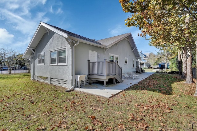 rear view of property featuring a lawn and a patio area