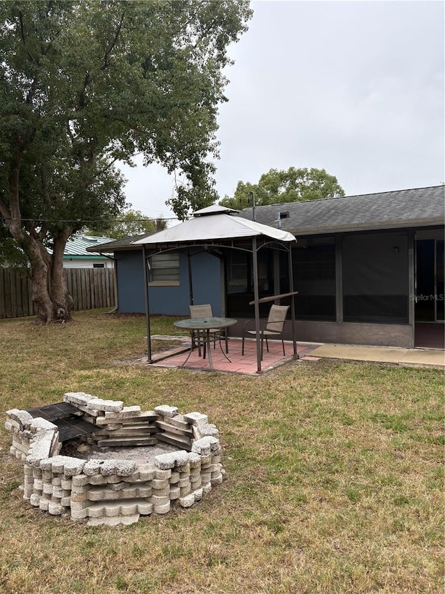 view of yard with a gazebo, a sunroom, an outdoor fire pit, and a patio