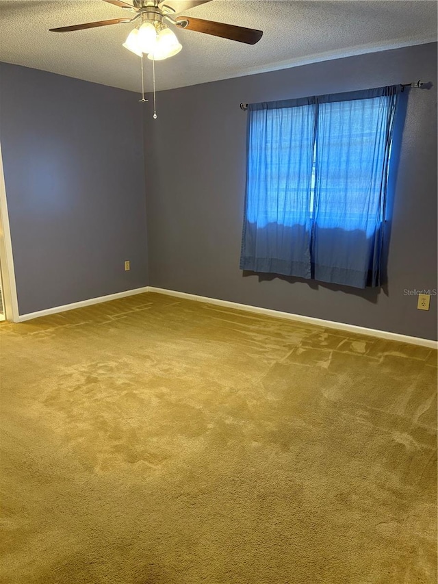 carpeted empty room with ceiling fan and a textured ceiling