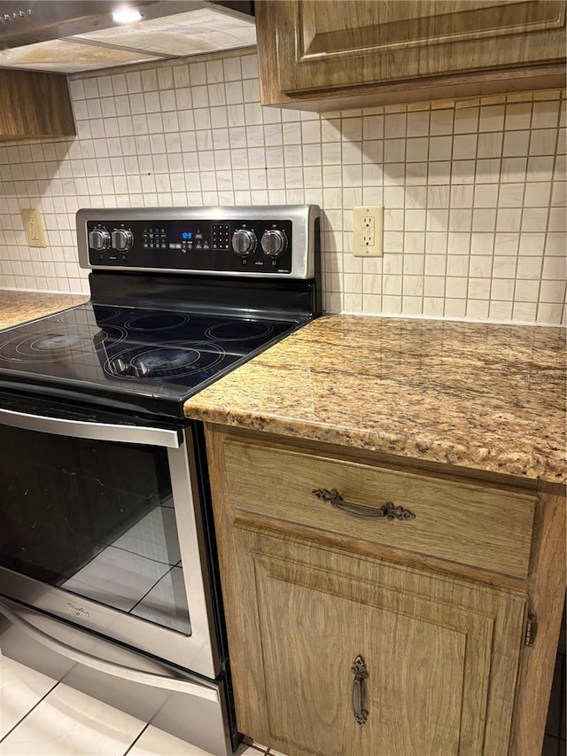 kitchen with light stone counters, backsplash, extractor fan, electric stove, and light tile patterned floors