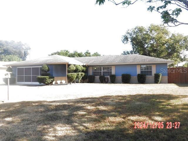 ranch-style house featuring a garage and a front lawn