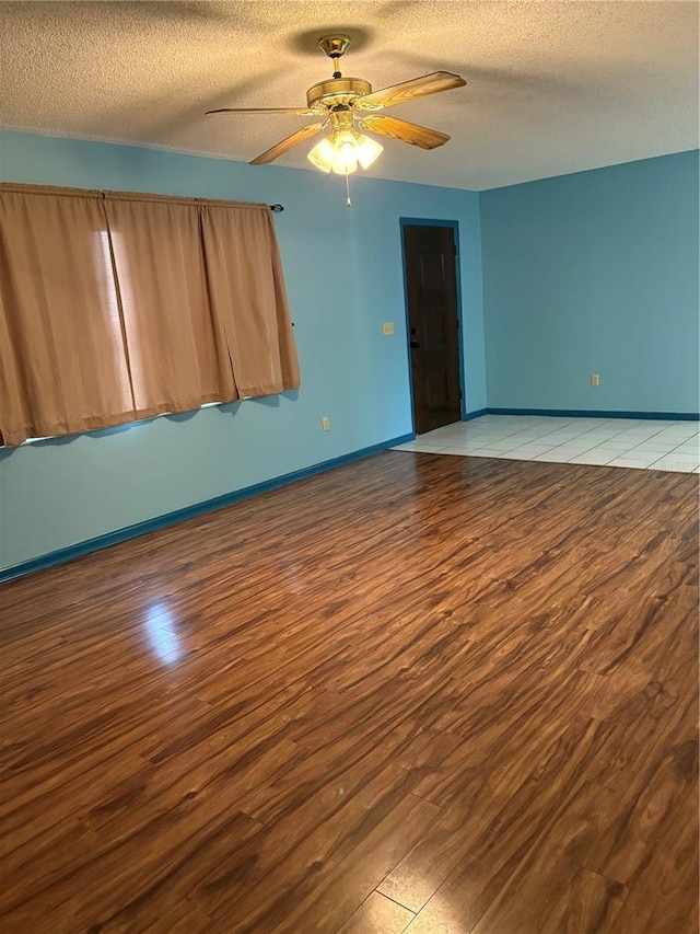 empty room featuring a textured ceiling, light hardwood / wood-style floors, and ceiling fan