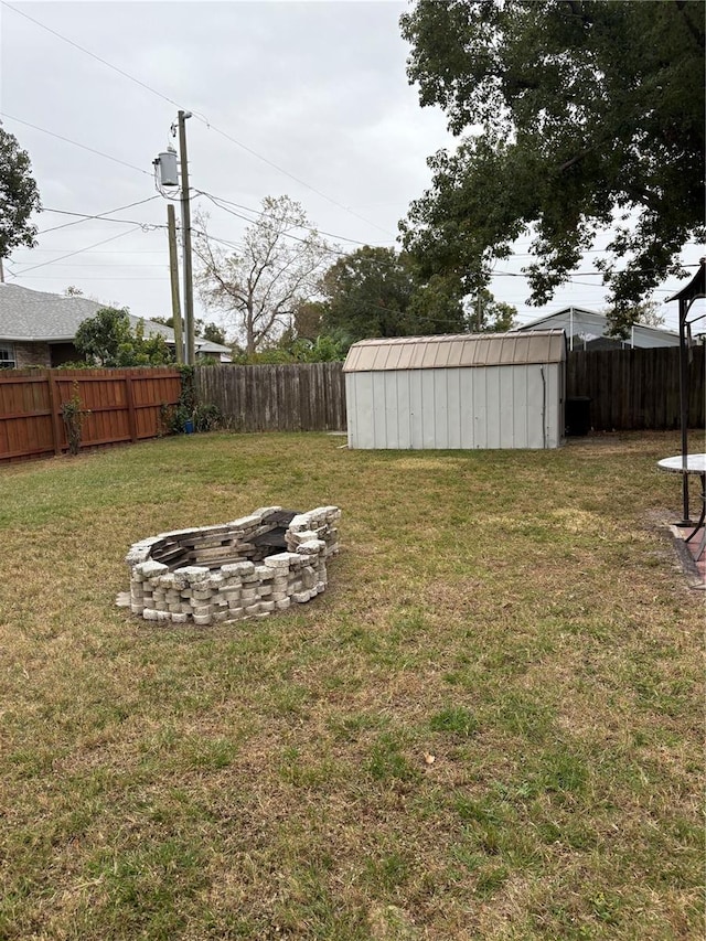 view of yard featuring a shed and an outdoor fire pit