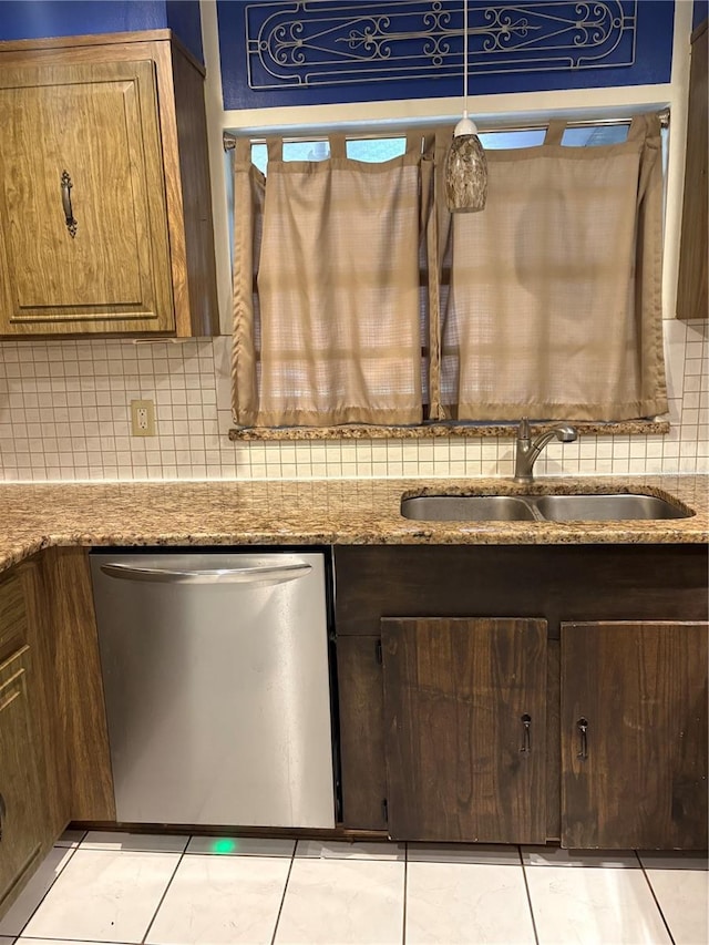 kitchen with light stone counters, tasteful backsplash, stainless steel dishwasher, and sink