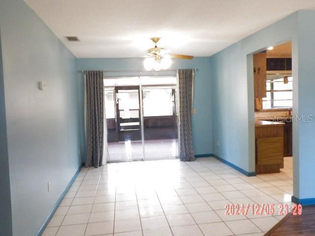 tiled spare room featuring ceiling fan