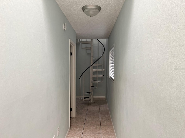 hallway with light tile patterned floors and a textured ceiling