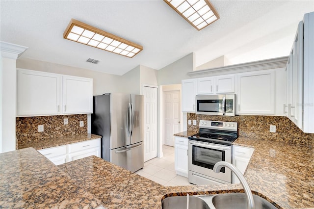 kitchen with backsplash, stainless steel appliances, vaulted ceiling, and sink