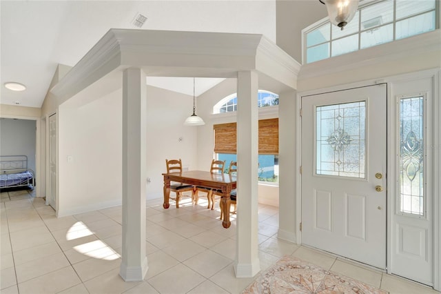 foyer entrance with light tile patterned floors and high vaulted ceiling