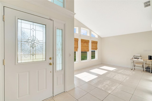 entryway featuring high vaulted ceiling, light tile patterned flooring, and a wealth of natural light